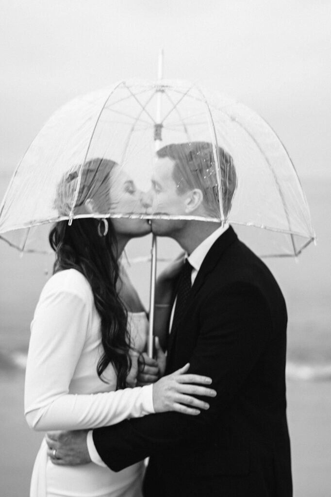 couple kisses under an umbrella