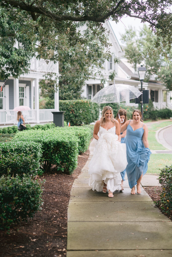 Bride and her bridesmaids walk under an umbrella